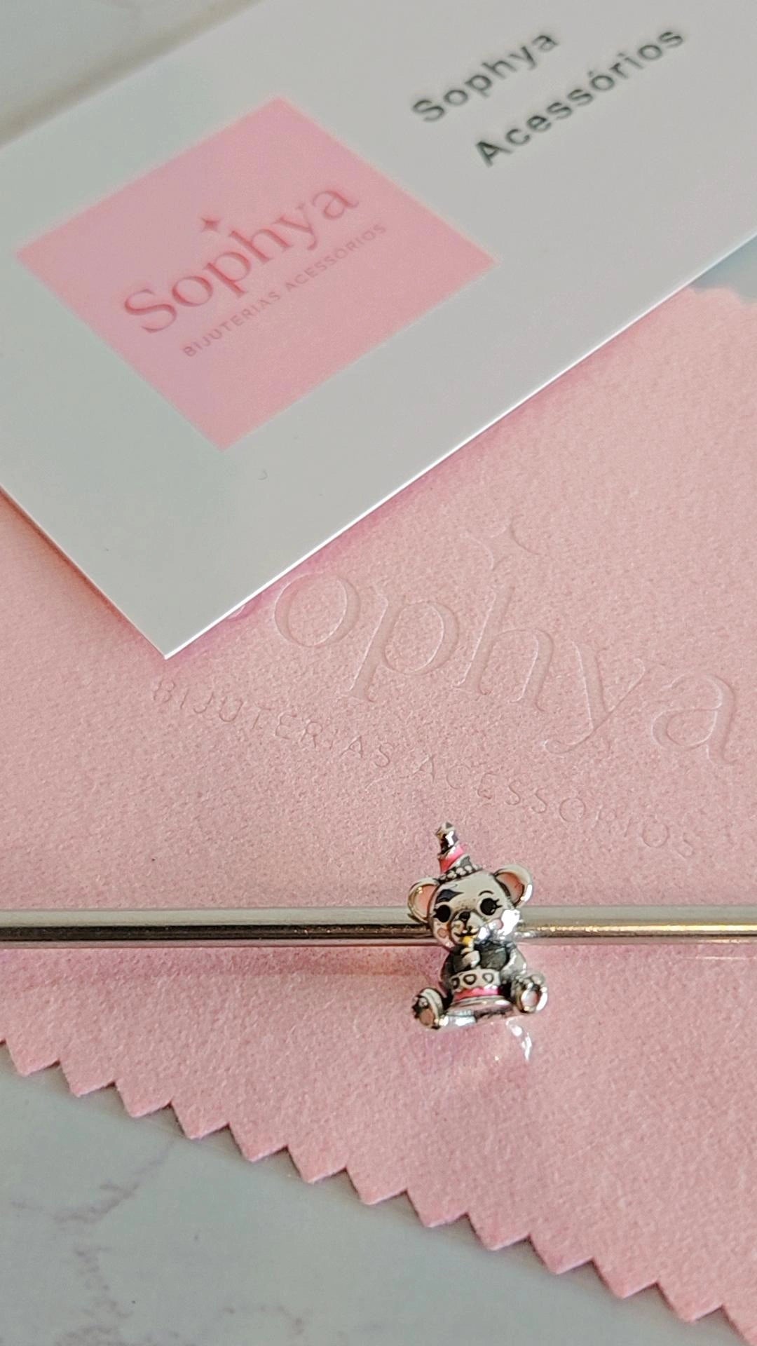 Esta é uma conta (berloque) de urso prateado com um chapéu de festa e um bolo, da marca Sophya Acessórios.