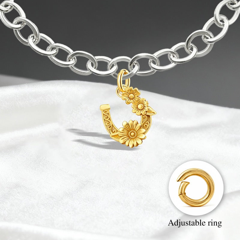 Este é um pendente de ferradura dourado com flores em relevo, com um fecho de argola ajustável.