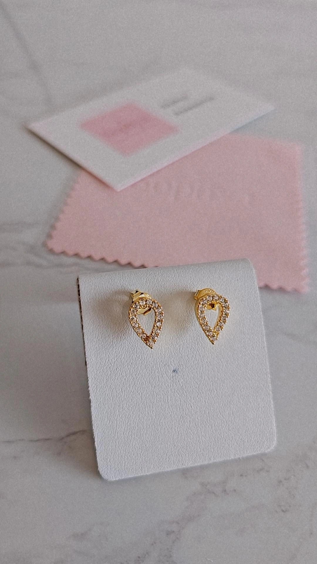 Estes são brincos de prata 925‰ com banho de ouro em forma de lágrima cravejados com zircónias.