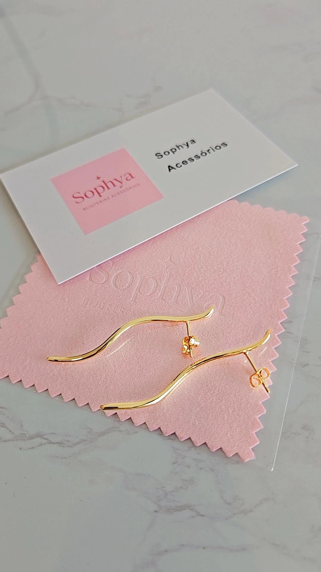 Este é um brinco feminino minimalista com design curvado, banhado a ouro 18K.